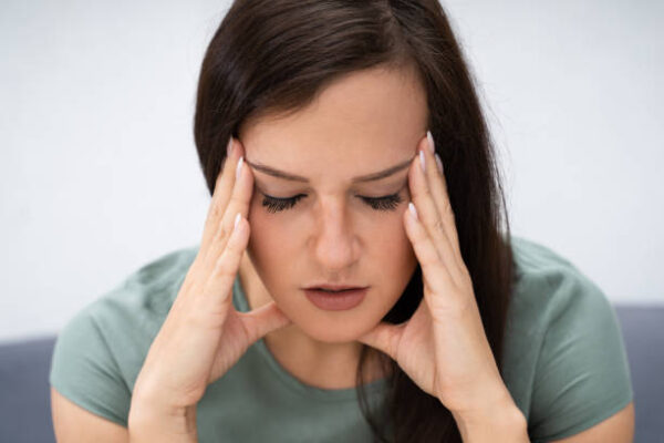 Young Woman Holding Head While Suffering From Headache